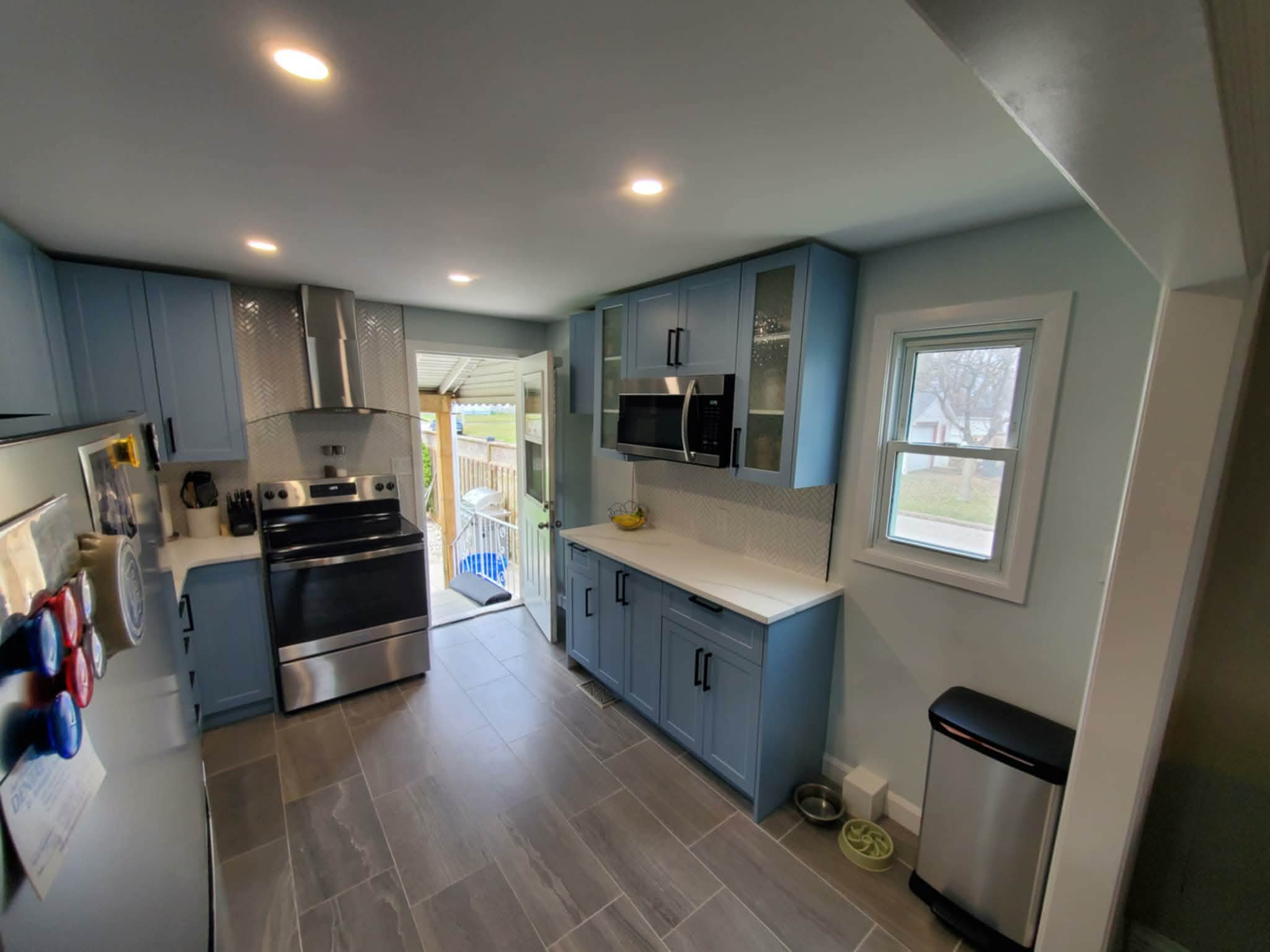 Sky Blue Kitchen with Quartz Counters and Herringbone Tile - After